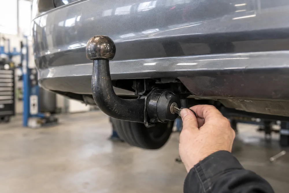 Nyckel i låset på en avtagbar dragkrok under en bil
